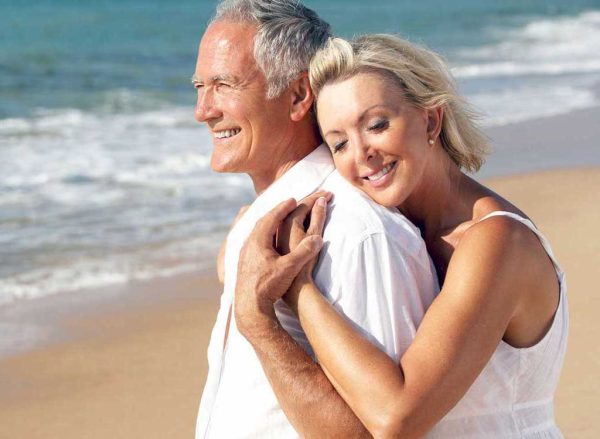 an older couple hugging on a Florida beach
