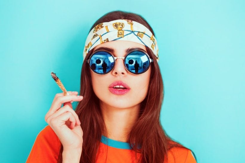 Hippie girl smoking weed and wearing sunglasses