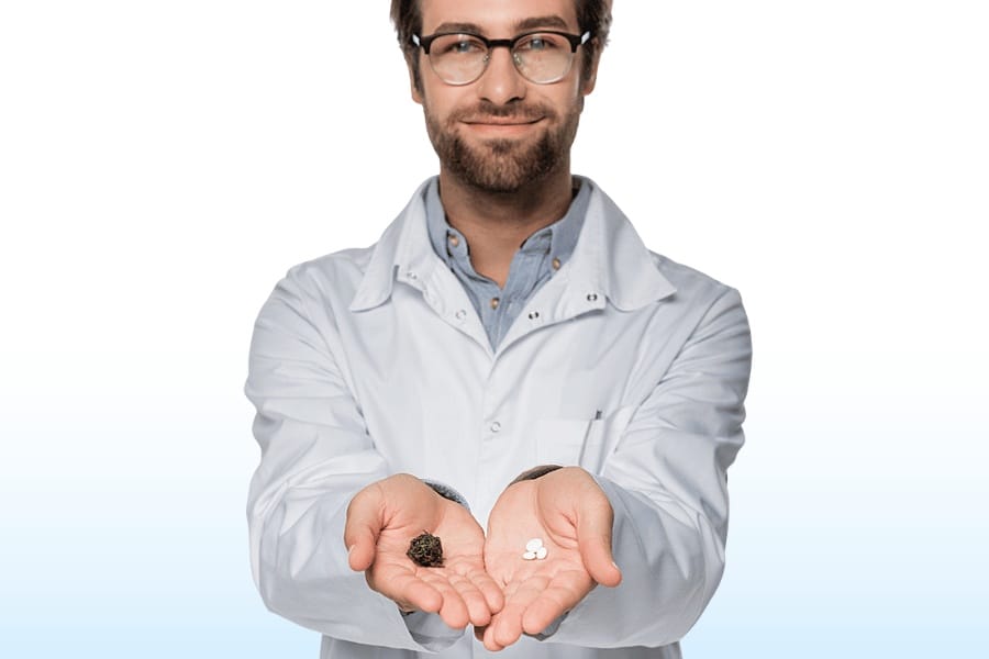 man holding cannabis in one hand and pills in another while smiling