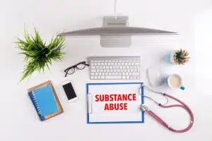 Office desk with SUBSTANCE ABUSE paperwork and other objects