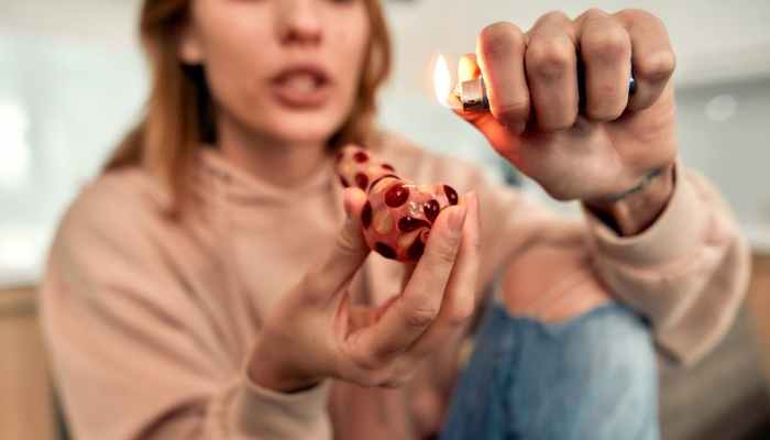 woman lighting a marijuana pipe